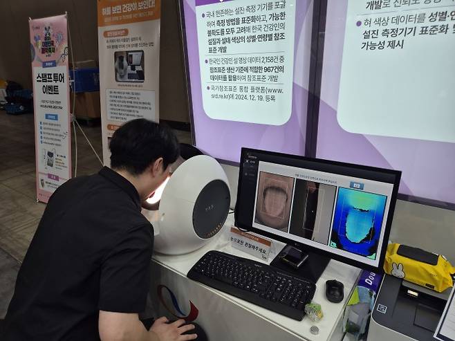 한국한의학연구원 부스에 마련된 인공지능(AI) 설진 체험 장치에 얼굴을 대고 있다. 임정우 기자 jjwl@donga.com