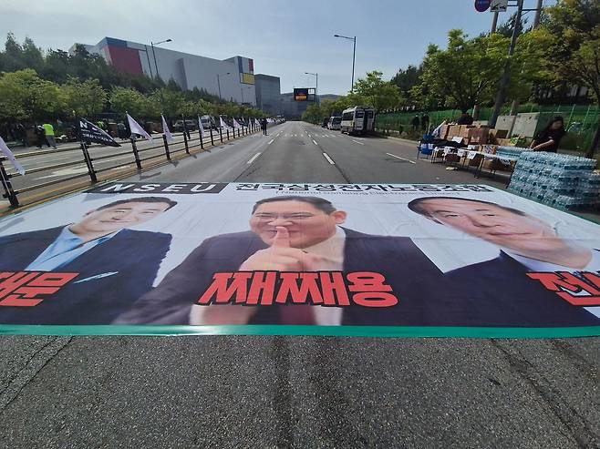 23일 대규모 집회를 예고한 삼성전자 노동조합이 경기 평택캠퍼스 내 도로에 이재용 회장과 전영현 부회장, 노태문 사장의 얼굴을 담은 플래카드를 붙여왔다. 이우림 기자
