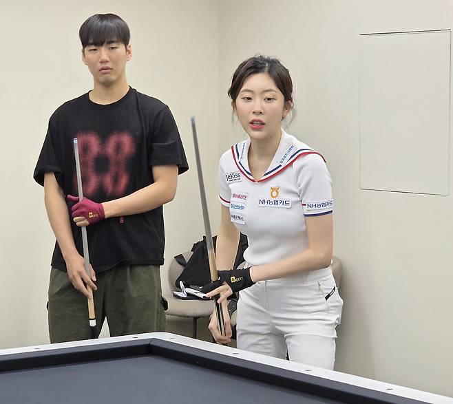 학생들에게 당구 시범을 보이는 PBA 여성부 정수빈(오른쪽)