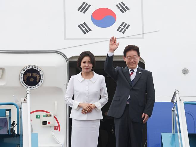 인도·베트남 국빈 방문 일정을 마치고 귀국하는 이재명 대통령과 김혜경 여사가 24일(현지시간) 베트남 하노이 노이바이 국제공항 공군 1호기에서 환송객들에게 인사하고 있다. [연합]