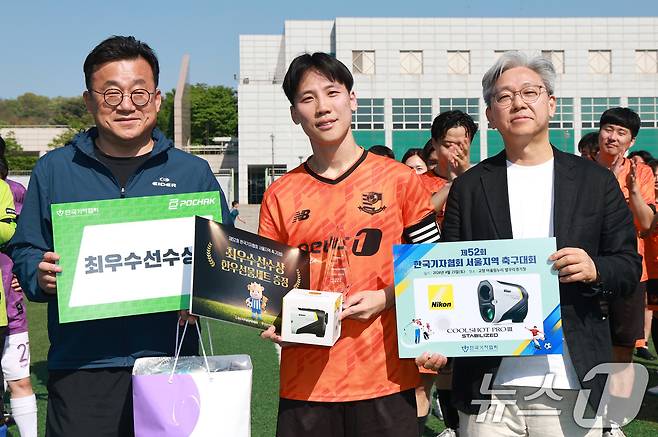 뉴스1 성동권 기자가 25일 경기 고양 어울림누리 별무리경기장에서 열린 기자협회 축구대회 시상식에서 최우수 선수상을 수상하고 있다. 이날 뉴스1은 결승전에서 국민일보와 전후반을 1-1로 마감, 승부차기 끝에 8-7로 승리해 대회 우승컵을 들어 올렸다. 오른쪽부터 이영섭 뉴스1 대표, 성동권 뉴스1 기자, 박종현 한국기자협회장. 2026.4.25 ⓒ 뉴스1 임세영 기자