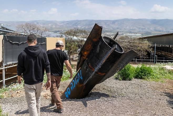 4월 9일(현지시각) 이란 미사일이 떨어진 이스라엘 점령지 요르단밸리의 한 정착촌에서 주민들이 잔해를 살피고 있다. Ilia YEFIMOVICH, AFP, 연합뉴스 제공