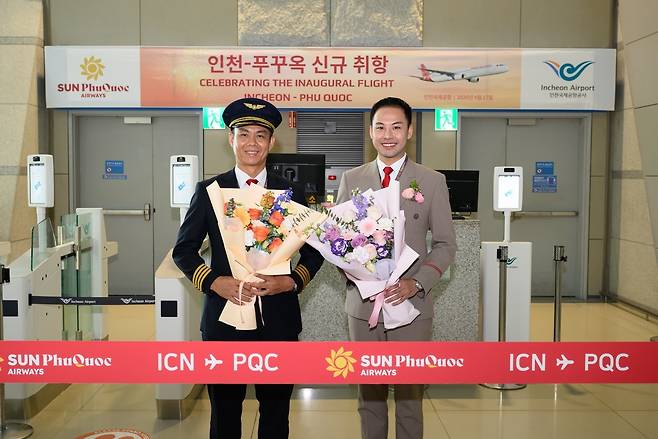Flight captain Nguyen Quoc Khanh (left) and cabin manager Tiep Vien Truong of Sun Phu Quoc Airways pose for a photo after a ribbon-cutting ceremony on Friday, marking the launch of the airline’s inaugural Incheon-Phu Quoc route. (Sun Group)