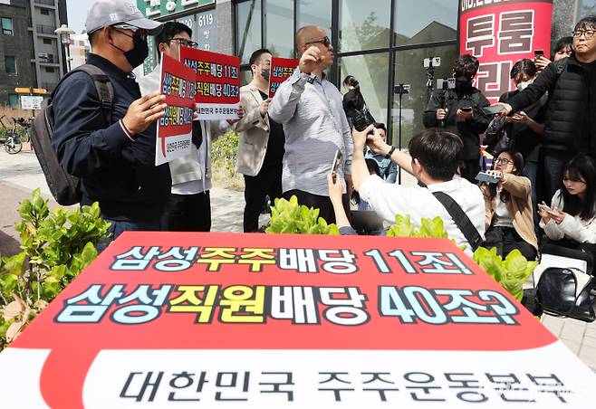 <yonhap photo-4988=""> 4월23일 삼성전자 노동조합 공동투쟁본부 투쟁 결의대회가 열리는 경기도 평택시 삼성전자 평택캠퍼스 인근에서 노조의 집회에 반대하는 대한민국 주주운동본부 관계자들이 결의문을 읽고 있다. 연합뉴스</yonhap>