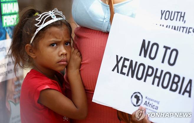 2022년 3월 남아프리카공화국 요하네스버그에서 열린 외국인 혐오 반대 행진에 참여한 어머니 옆에 선 소녀 [로이터=연합뉴스 자료사진. 재판매 및 DB 금지]