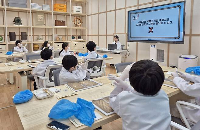 ▲&nbsp;국립인천해양박물관 개방형 수장고에서 진행된 '2025 유물관리 교육 프로그램'에서 참가자들이 유물 관리 과정을 배우고 있다./제공=국립인천해양박물관&nbsp;