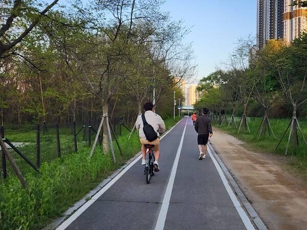 인천 송도달빛공원의 자전거도로에 자전거 이용자와 보행자들이 함께 걷고 있다.