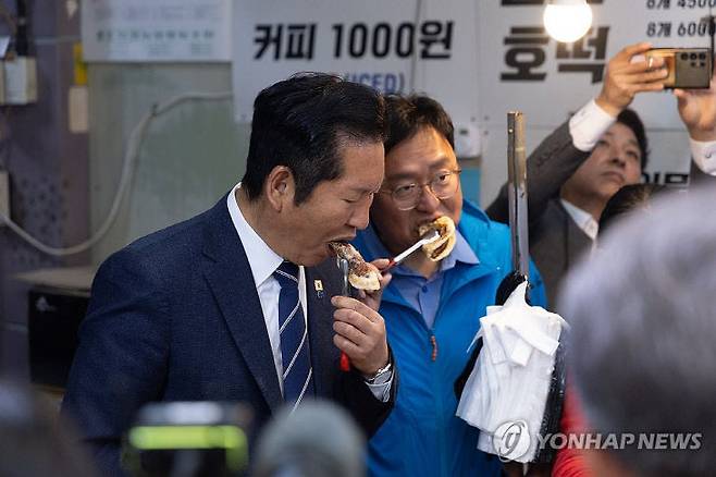 더불어민주당 정청래 대표가 25일 세종시 세종전통시장을 방문해 민주당 조상호 세종시장 후보와 호떡을 먹고 있다./사진=연합뉴스
