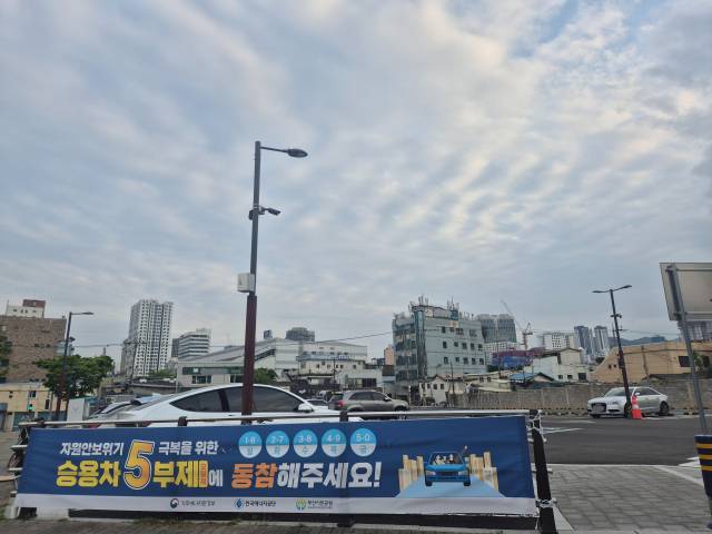 지난 20일 오후 부산 부산진구 부산시민공원 남문 인근의 한 공영주차장에 5부제 시행을 알리는 현수막이 걸려있다. 김동우 기자 friend@