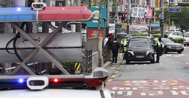 단속 경찰관에게 적발되면 운전자에게 범칙금과 벌점이 부과된다. 연합뉴스