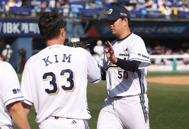 이영하가 26일 잠실구장에서 열린 LG 트윈스와 경기서 이닝을 마친 뒤 동료들과 하이파이브를 하고 있다./두산 베어스