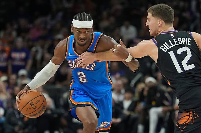 오클라호마시티 샤이 길저스-알렉산더(왼쪽)가 26일(한국시간) 모기지 매치업 센터에서 열린 NBA&nbsp;PO&nbsp;1라운드 3차전 도중 콜린 길레스피의 수비를 피해 돌파를 시도하고 있다. 피닉스｜AP뉴시스