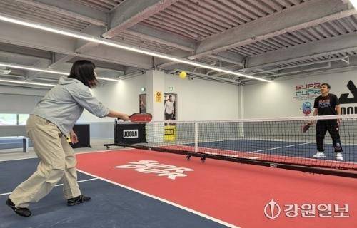 ◇25일 찾은 춘천시의 한 실내 피클볼센터. 강원일보 사회체육부 고은기자가 센터대표 J.C에게 피클볼 강습을 받고 있다. 노란색 피클볼 공을 처음으로 받아친 모습. 사진=독자제공