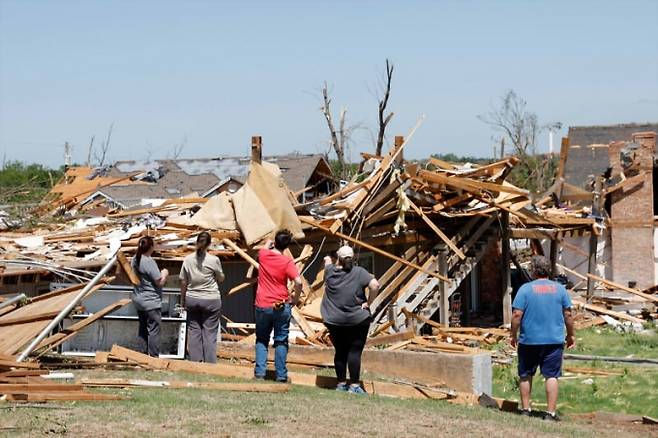 ▲24일(현지시간) 미국 오클라호마주 에니드 그레이리지 지역에서 사람들이 토네이도 피해 상황을 살펴보고 있다.(사진=AP연합뉴스)
