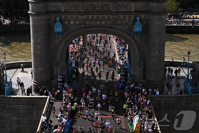 2026 런던 마라톤 참가자들이 26일 영국 런던의 타워브릿지를 지나가고 있다. ⓒ 로이터=뉴스1