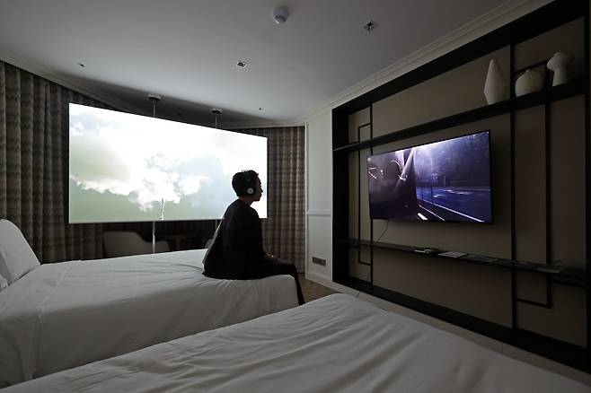 그랜드조선 부산 호텔의 객실에서 한 관람객이 다이얼로그 갤러리가 선보인 타티아나 마세도의 작품을 감상하고 있다. /뉴시스