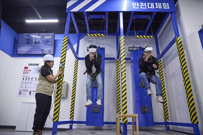 지난 24일 SK텔레콤 대전 안전체험교육관에서 취재진이 VR 헤드셋을 착용하고 안전대 추락 체험에 참여하고 있다.