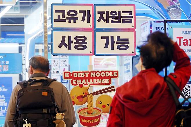 '고유가 피해지원금' 1차 지급을 하루 앞둔 26일 서울 시내의 한 편의점에 고유가 지원금 사용 가능 안내문이 붙어 있다. 연합뉴스