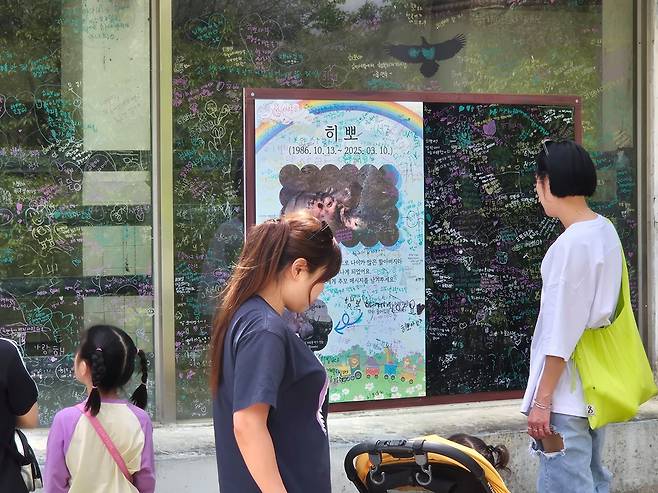 26일 오후 광주광역시 북구 우치동물원에서 방문객들이 하마사 외벽에 적힌 하마 '히뽀'의 추모글을 보고 안타까워하고 있다. 황희규 기자