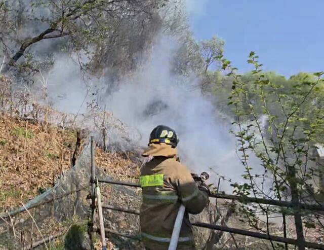 포천 신북면 야산에서 발생한 산불이 진화된 뒤 잔불 정리 작업이 이어지며 연기가 피어오르고 있다. 포천소방서 제공