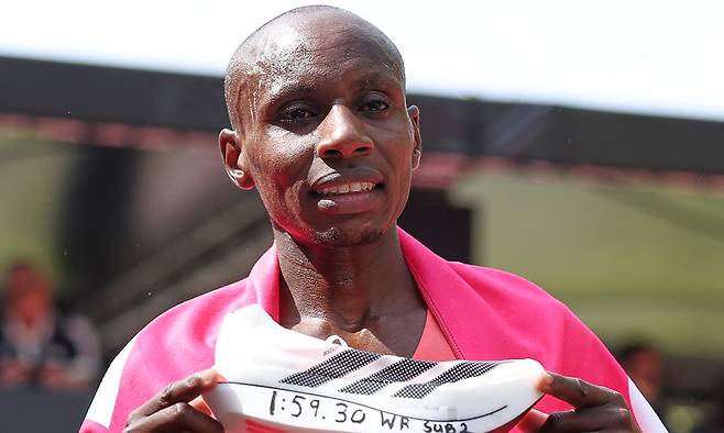 세바스티안 사웨(케냐)가 지난 26일 2026 런던 마라톤에서 1시간59분30초로 완주해 인류 최초로 2시간의 벽을 깨며 우승을 차지한 뒤 자신의 러닝화에 자신의 기록을 써넣은 뒤 기념촬영을 하고 있다. 런던=신화통신연합뉴스