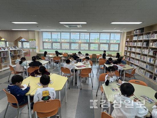 ▲ 복산초 학생들이 도서관에서 '나만의 책표지 꾸미기' 활동을 하고 있다.