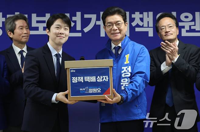 정원오 더불어민주당 서울시장 후보가 28일 서울 중구 선거대책위원회 사무실에서 열린 공개 선거대책위원회 회의에서 김형남 상임선대위원장으로부터 서울 25개 자치구 정책 공약이 담긴 택배상자를 전달받고 있다. 2026.4.28 ⓒ 뉴스1 오대일 기자