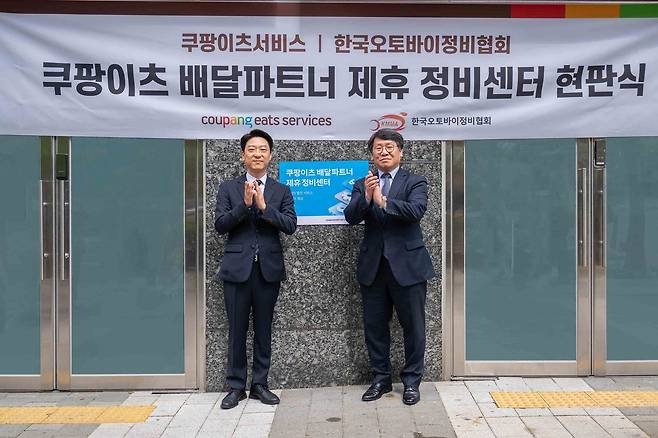 강동진 쿠팡이츠서비스 상무(왼쪽)와 이형석 한국오토바이정비협회 회장이 28일 서울 마포구 소재 쿠팡이츠서비스 제휴 정비센터에서 현판식을 기념하고 있다.(쿠팡 제공)