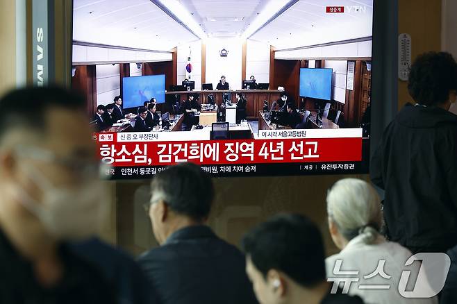 28일 오후 서울시 용산구 한강대로 서울역 대합실에서 시민들이 자본시장과 금융투자업에 관한 법률 위반, 정치자금법 위반, 특정범죄 가중처벌 등에 관한 법률 위반(알선수재) 혐의를 받는 김건희 여사의 항소심 선고공판 생중계를 지켜보고 있다. 2026.4.28 ⓒ 뉴스1 박정호 기자