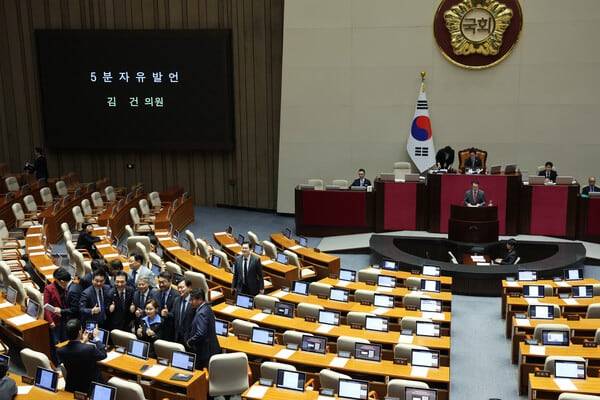 더불어민주당 의원들이 28일 오후 서울 여의도 국회에서 열린 본회의에서 정동영 통일부 장관 해임 건의안 취지를 설명하는 김건 국민의힘 의원을 뒤로 하고 기념 사진을 찍고 있다. /뉴시스