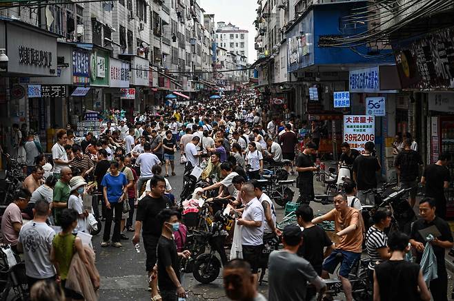 지난 16일 중국 남부 광둥성 광저우의 한 도시 거리에서 의류 공장 채용 담당자들과 일자리를 찾는 노동자들을 촬영한 모습 / AFP=연합