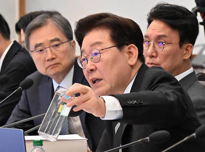 이재명 대통령이 28일 오전 청와대에서 열린 제18회 국무회의 겸 제6차 비상경제점검회의에 참석해 기후에너지장관의 보고를 받던중 재활용이 불가능한 용기를 들어보이고 있다. 2026.4.28 청와대사진기자단