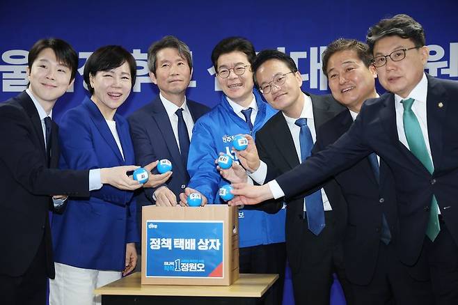더불어민주당 정원오 서울시장 후보(가운데)가 28일 서울 중구 선거대책위원회 사무실에서 열린 선거대책위 회의에 참석, 상임 선대위원장들과 함께 서울시 정책 공약을 택배상자에 넣는 퍼포먼스를 하고 있다. 연합뉴스