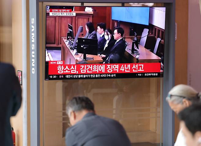 28일 서울역 대합실에서 시민들이 통일교 금품 수수와 도이치모터스 주가조작, 명태균 무상 여론조사 등의 혐의를 받는 김건희 여사 항소심 선고공판 생중계를 시청하고 있다. 이날 항소심 재판부는 김건희 여사에게 징역 4년, 벌금 5천만원을 선고했다. 연합뉴스
