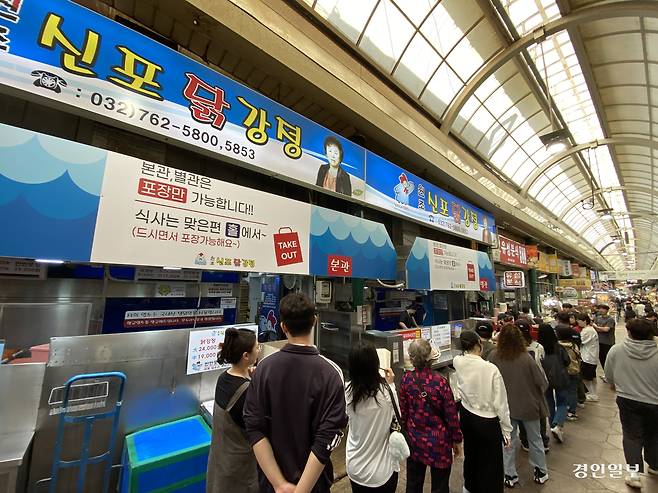 지난 24일 오후, 인천 신포국제시장의 대표 먹거리인 닭강정과 공갈빵을 맛보려는 손님들이 긴 줄을 서며 기다리고 있다. 2026.4.24 /조재현기자 jhc@kyeongin.com