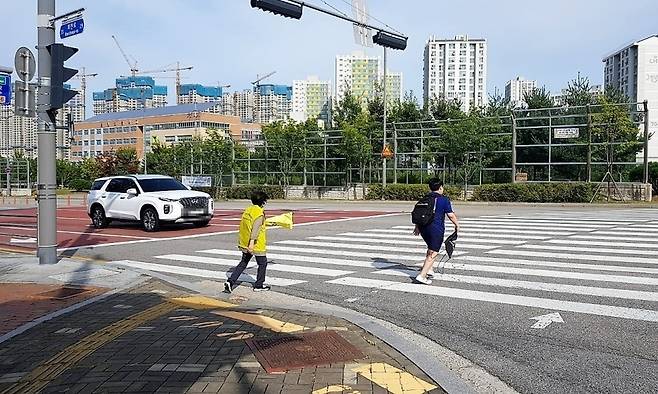 ▲ 양주시의 한 초등학교 앞 교차로에서 교통안전 지도사의 도움을 받아 학생들이 횡단보도를 건너고 있다. 인구 50만 대도시 진입을 앞두고 교육 행정 수요가 급증한 양주시는 최근 교육지원청 설치 권한의 조례 이양에 발맞춰 단독 신설을 위한 행정 절차에 속도를 내고 있다. /이광덕 기자 kdlee@incheonilbo.com