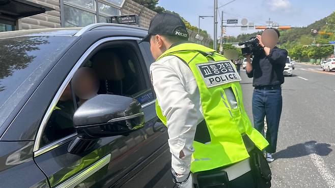 경찰이 우회전 단속에 적발된 차량에 계도 조치를 진행하며 주의를 당부하고 있다. 사진=오민지 기자