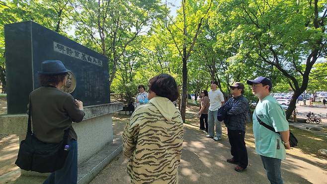 목우 백기만 작가의 문학비 앞에서 상화와 고월 이장희를 알린 백기만의 역할과 성과에 대한 설명을 듣고 있는 모습.