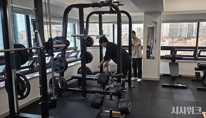 동작장애인전용헬스장에 상주하고 있는 홍성윤 체육지도사가 파킨슨병을 갖고 있는 장애인 당사자에게 운동을 알려주고 있는 모습이다. / 사진=이민지 기자