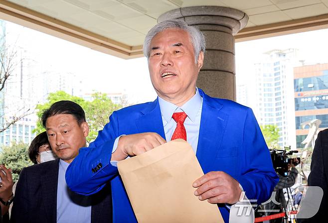 서울서부지법 난동 사태 배후로 지목돼 수건조물침입교사 혐의 등으로 기소된 전광훈 사랑제일교회 목사가 17일 서울 마포구 서울서부지법에서 열린 재판을 마치고 입장문을 취재진에게 건네고 있다. 2026.4.17 ⓒ 뉴스1 이호윤 기자