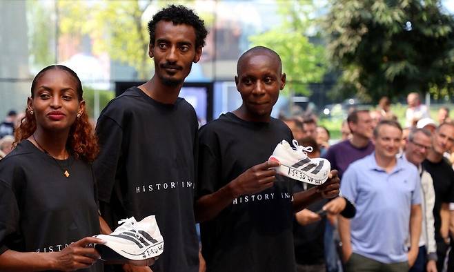 마라톤 풀코스를 2시간 미만에 완주한 최초의 인물이 된 사바스티안 사웨가 지난 28일(현지시각) 독일 헤르초게나우라흐에서 열린 아디다스 행사에 참석해 자신이 신고 뛰었던 신발을 들고 있다. 헤르초게나우라흐/로이터 연합뉴스