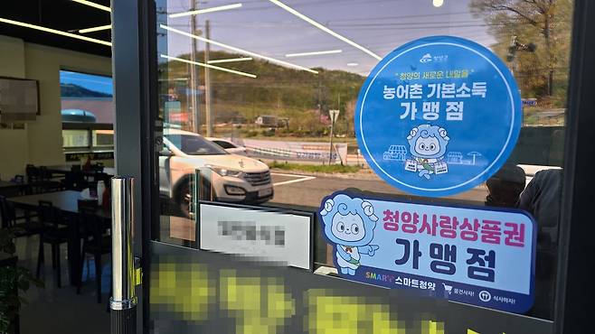 지난 14일 오후 충남 청양군 청양읍의 한 점포에 농어촌기본소득을 사용할 수 있는 '청양사랑상품권 가맹점' 스티커가 붙어 있다. 신진호 기자