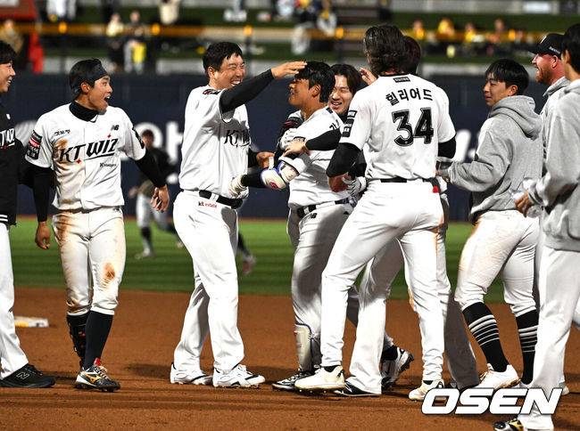 [OSEN=수원, 이대선 기자] 프로야구 KT 위즈가 LG 트윈스를 꺾고&nbsp;1~2위 빅매치에서 웃었다.KT는&nbsp;28일 수원 KT위즈파크에서 열린 2026 KBO리그 LG와 경기에서 연장 10회 6-5 끝내기 승리를 거뒀다.&nbsp; KT는 18승 8패로 1위 자리를 지켰고, LG는 16승 9패로 1.5경기 차이로 밀려났다.경기 종료 후 끝내기 안타를 친 KT 강민성이 동료들의 축하를 받고 있다. 2026.04.28 /sunday@osen.co.kr