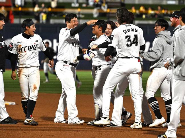 [OSEN=수원, 이대선 기자] 프로야구 KT 위즈가 LG 트윈스를 꺾고&nbsp;1~2위 빅매치에서 웃었다.KT는&nbsp;28일 수원 KT위즈파크에서 열린 2026 KBO리그 LG와 경기에서 연장 10회 6-5 끝내기 승리를 거뒀다.&nbsp; KT는 18승 8패로 1위 자리를 지켰고, LG는 16승 9패로 1.5경기 차이로 밀려났다.경기 종료 후 끝내기 안타를 친 KT 강민성이 동료들의 축하를 받고 있다. 2026.04.28 /sunday@osen.co.kr