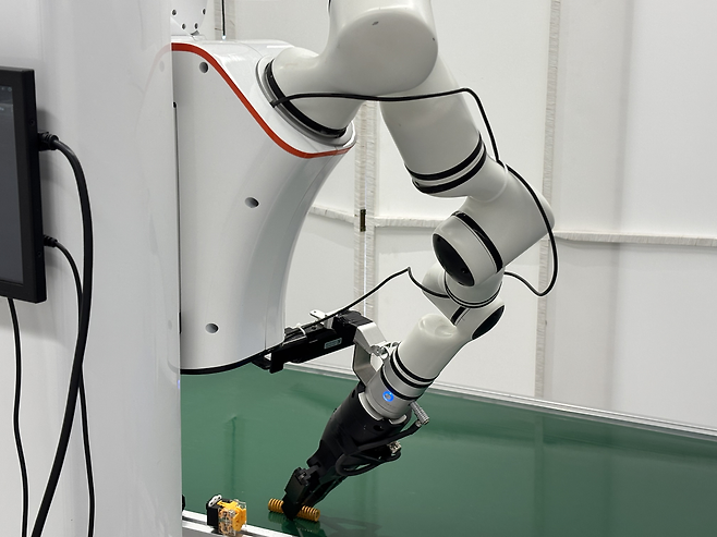 28일 베이징 스징산구 휴머노이드 로봇 훈련중심에서 리얼맨의 로봇 팔이 생산라인 부품을 집고 있다. 베이징=정다은 특파원