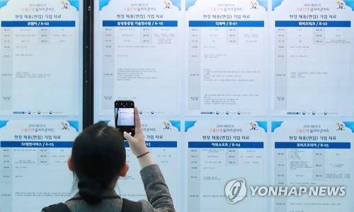 미래의 고민을 담다 2019년 3월 '2019 대한민국 고졸인재 일자리 콘서트'를 찾은 한 취업준비생이 채용정보 게시판을 살펴보던 중 현장 채용 기업 자료를 사진으로 찍고 있다. [연합뉴스 자료사진]