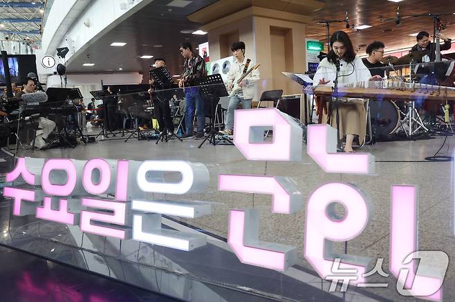 최휘영 문화체육관광부 장관이 1일 오후 서울 중구 서울역에서 열린 '문화가 있는 날' 확대 기념 행사에서 기타를 연주하며 공연에 참여하고 있다. 2026.4.1 ⓒ 뉴스1 이광호 기자