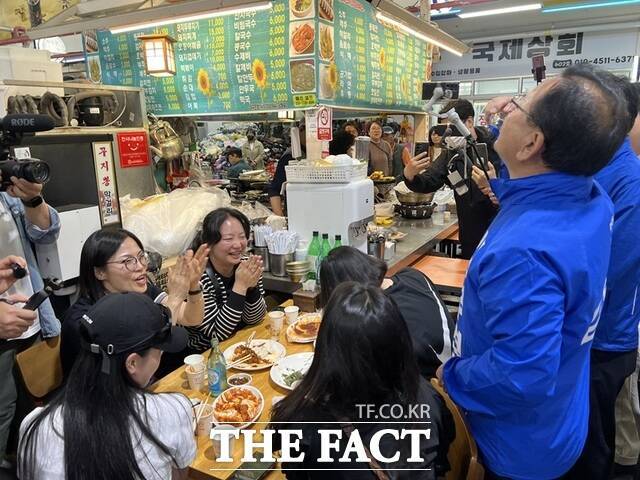 김부겸 민주당 대구시장 후보(오른쪽)가 30일 달성군 현풍장에서 술자리를 갖는 여성들의 권유로 소주를 마시고 있다. /김부겸 선거 캠프