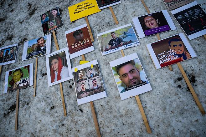 지난 1월10일(현지시간) 독일 베를린에서 반이란 시위가 열리는 도중 이란 정권에 의해 처형된 이들의 사진이 길 위에 놓여 있다. AFP연합뉴스