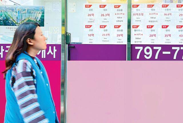한 시민이 지난 27일 서울 용산구 동부이촌동 아파트 단지 인근 한 부동산 중개업소 앞을 지나가고 있다. 이재명 대통령이 다음달 9일부로 양도세 중과 유예를 종료한다고 밝힌 지 3개월여가 지났지만 서울 최상급지는 한산한 분위기였다. 조효석 기자